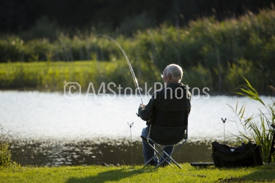 Coarse fisherman playing a fish