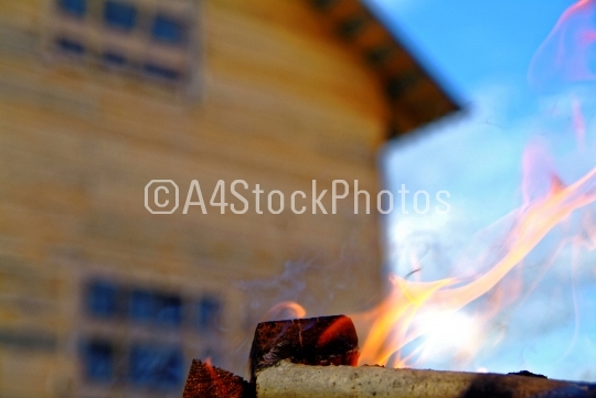 firewood burning on blue sky background in summer
