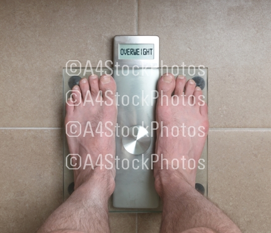 Man's feet on weight scale - Overweight