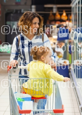 Mother and daughter shopping for groceries in supermarket.
