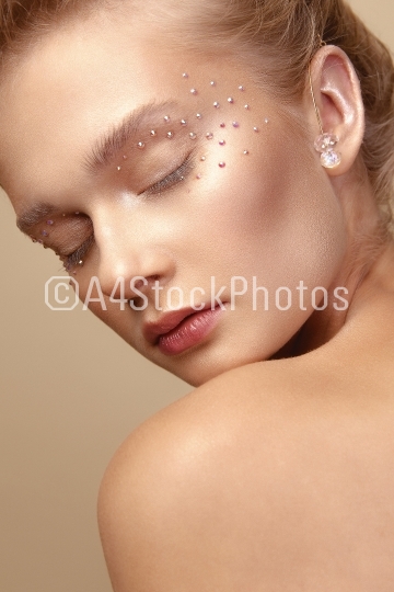 Portrait of cute blonde girl with art makeup