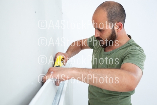 Worker building plasterboard wall.