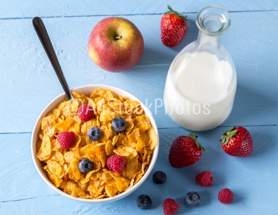 Cornflakes in a bowl with milk and fruits