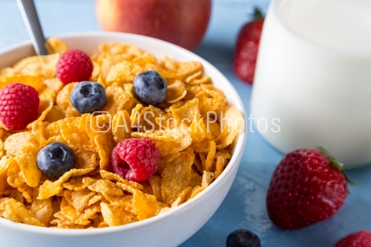 Cornflakes in a bowl with milk and fruits