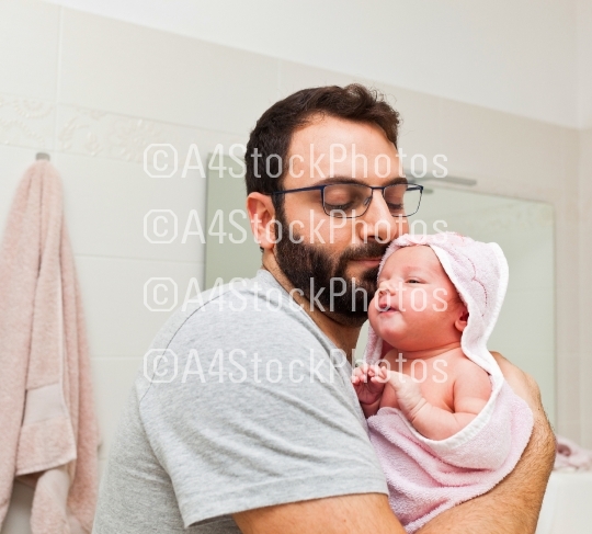 Dad holds his daughter in his arms after the first bath.
