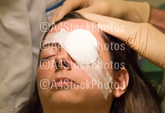 Doctor covering eye of patient by medical plaster