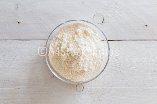 Flour in a bowl on wooden table