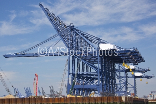 Giant dockside cranes against a bright blue sky