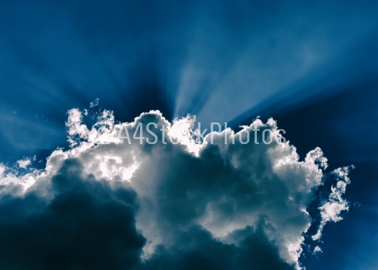 Horizontal blue dramatic cloudscape with rays of light abstracti