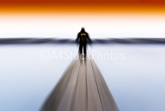 Horizontal radial blur man on pier abstract with orange sky back