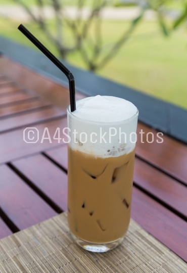 Iced coffee in a glass with milk froth