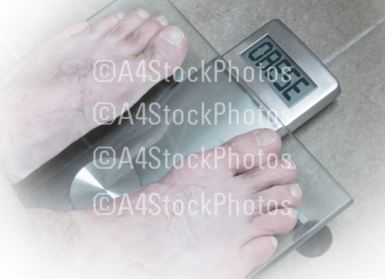 Man's feet on weight scale - Obese