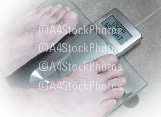 Man's feet on weight scale - Overweight