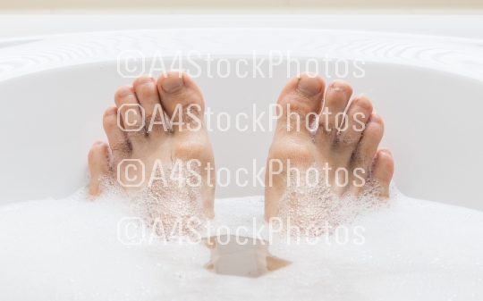 Men's feet in a bathtub, selective focus on toes