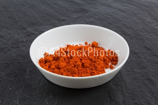 Paprika in a bowl on a slate