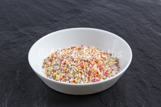 Sugar sprinkles in a bowl on a slate