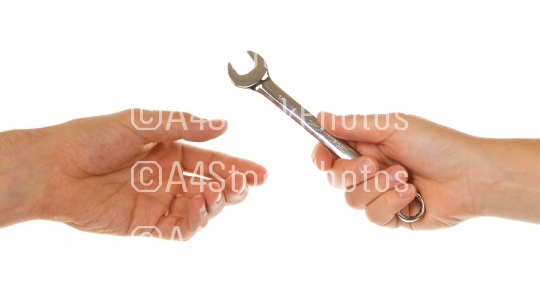 Woman giving wrench to man