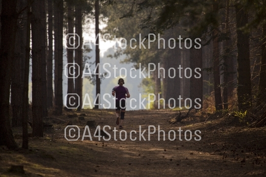 Woman jogging along a forest path