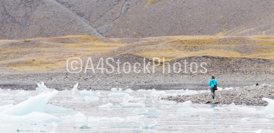 Woman walking over the beach at Jokulsarlon glacier lagoon - Ice