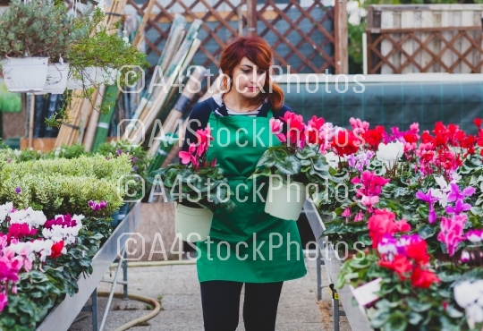 Young florist with red hair works in a nursery.