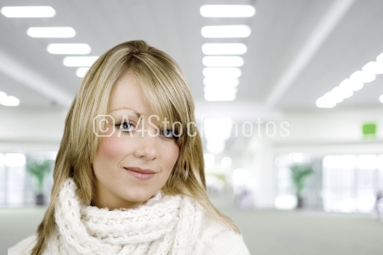 Young womn or girl looking at camera, blurred office or terminal
